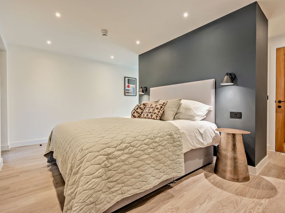 A bedroom with a bed and nightstand at Whalesborough Penthouse 2.0 in Marhamchurch