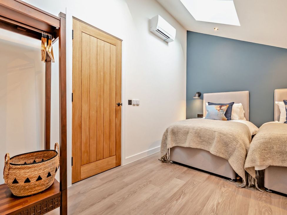 A bedroom with two beds and a basket at Whalesborough Penthouse 2.0 in Marhamchurch
