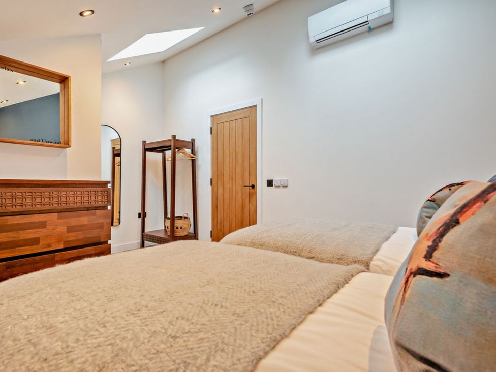 A bedroom with two beds and a mirror at Whalesborough Penthouse 2.0 Marhamchurch