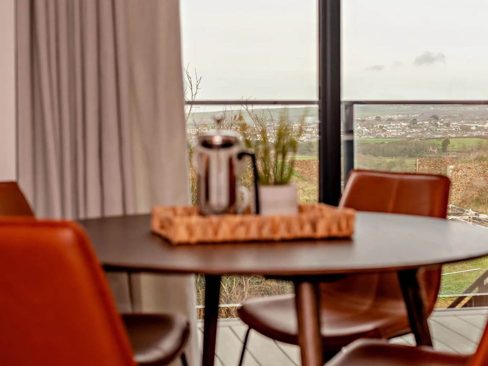 A dining room with a table and chairs at Whalesborough Penthouse 2.0 Marhamchurch