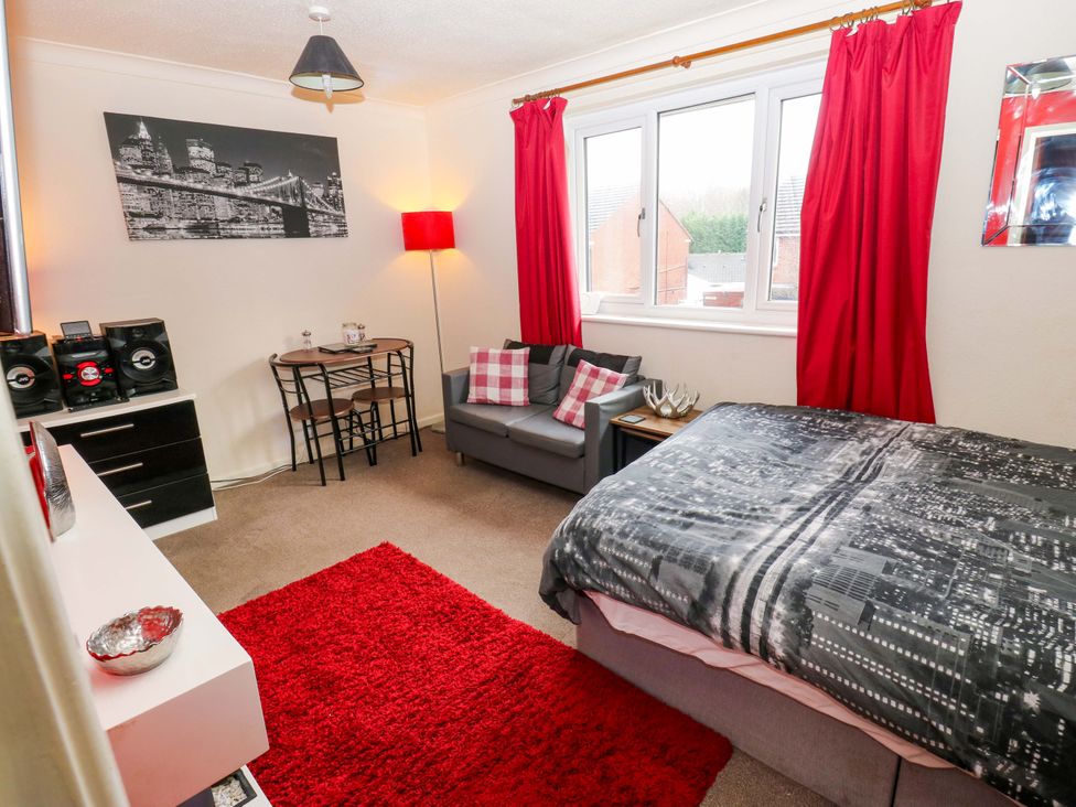 A bedroom with a bed, sofa and dining table at Cosy Nook Leeds