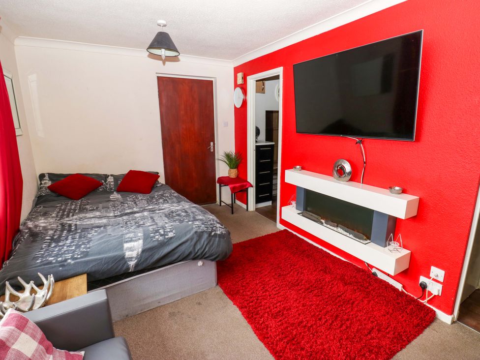 A living room with a bed and TV at Cosy Nook in Leeds