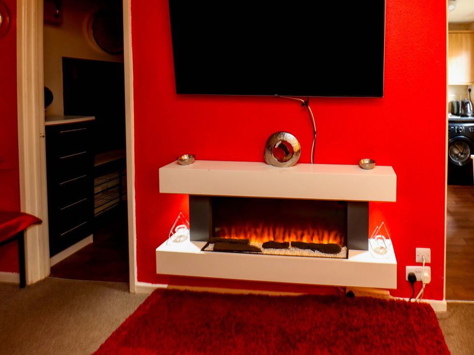 A living room with a fireplace and TV at Cosy Nook in Leeds