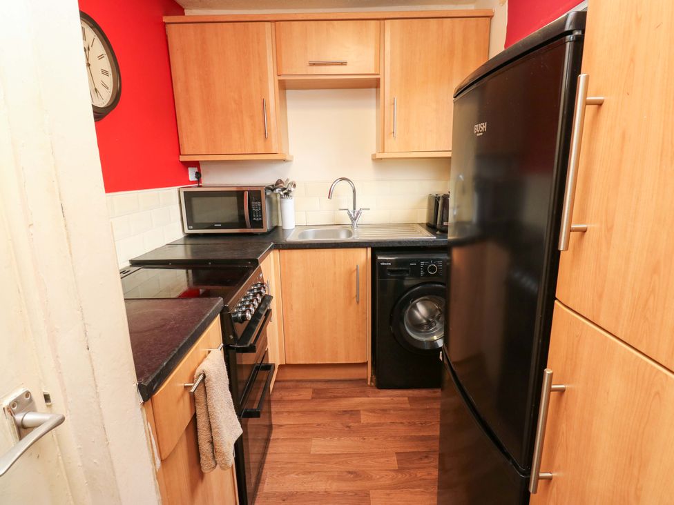 A kitchen with appliances and a sink at Cosy Nook in Leeds