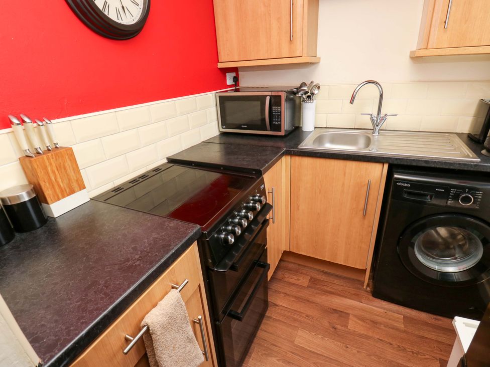 A kitchen with appliances and a sink at Cosy Nook Leeds