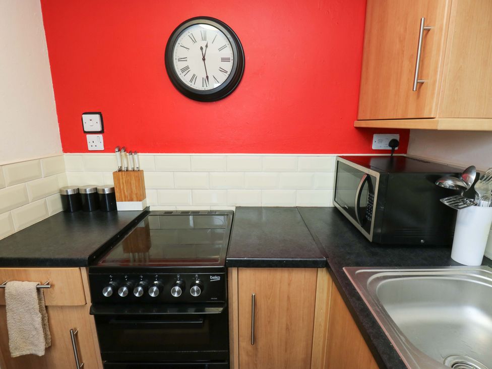 A kitchen with stove and microwave at Cosy Nook in Leeds