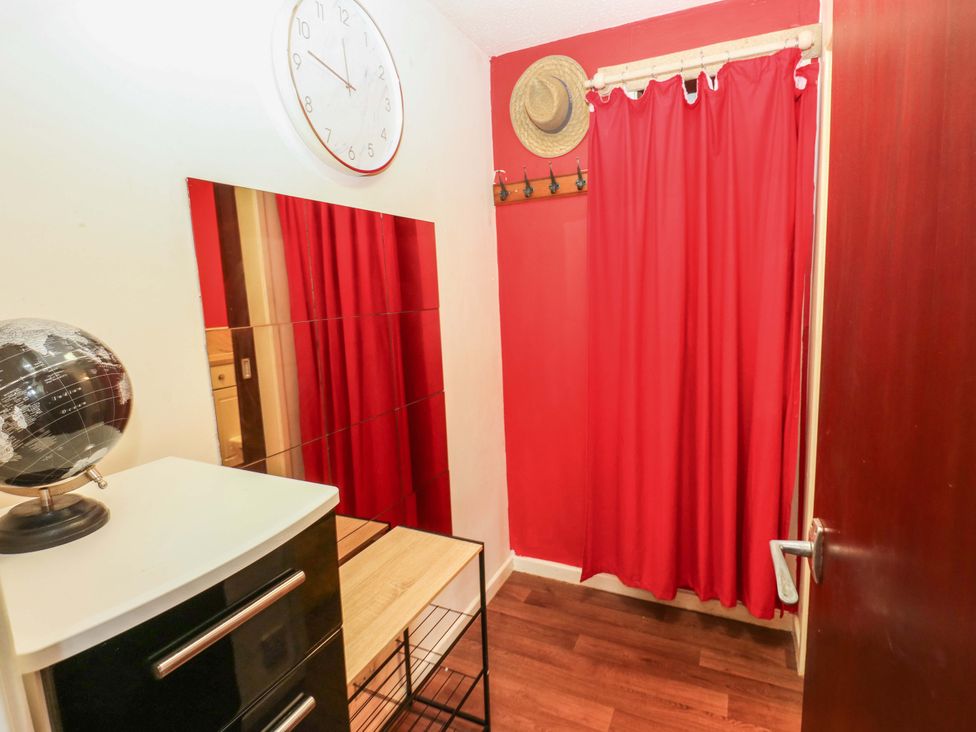 A hallway with a clock and mirror at Cosy Nook in Leeds