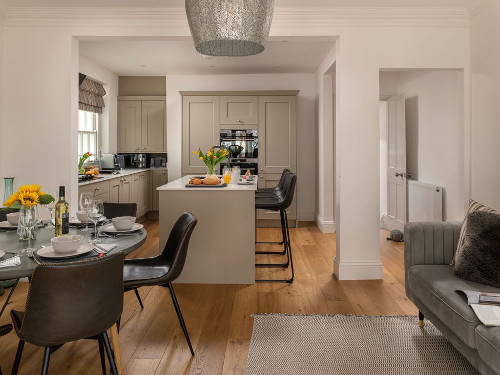 A kitchen with a dining area and bar stools at Tides Door in Dartmouth