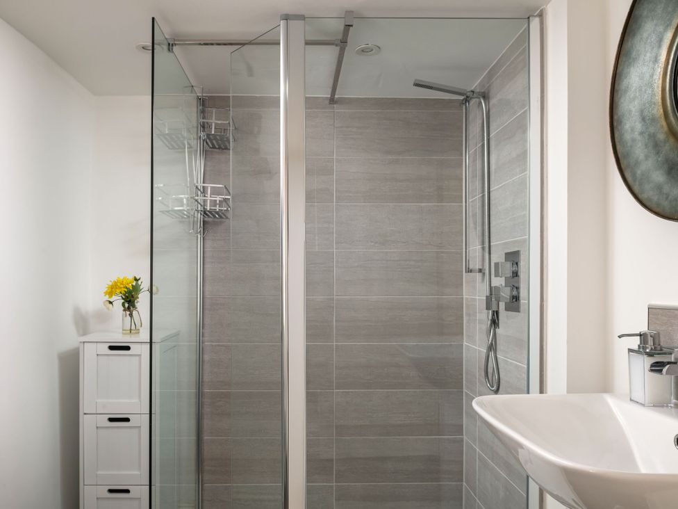 A bathroom with a shower and sink at Tides Door in Dartmouth