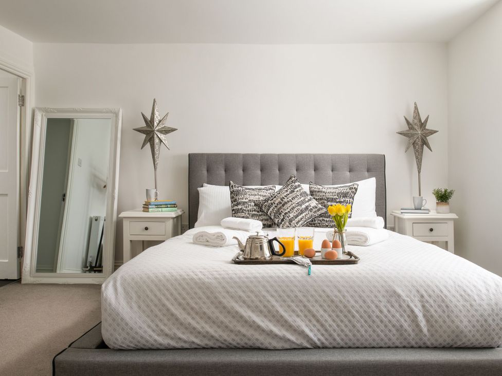 A bedroom with a bed and breakfast tray at Tides Door in Dartmouth