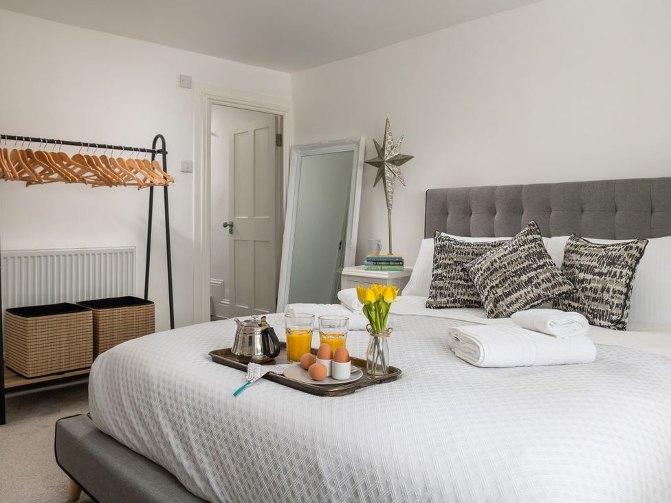 A bedroom with a bed and a breakfast tray at Tides Door in Dartmouth