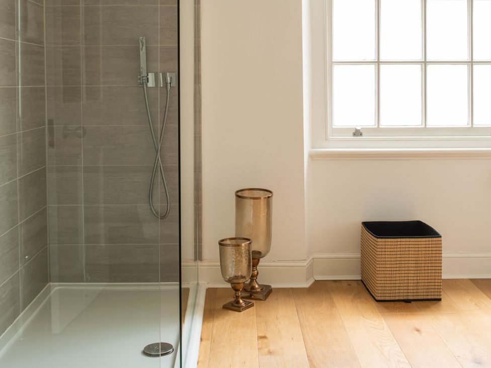 A bathroom with a shower and decorative items at Tides Door in Dartmouth