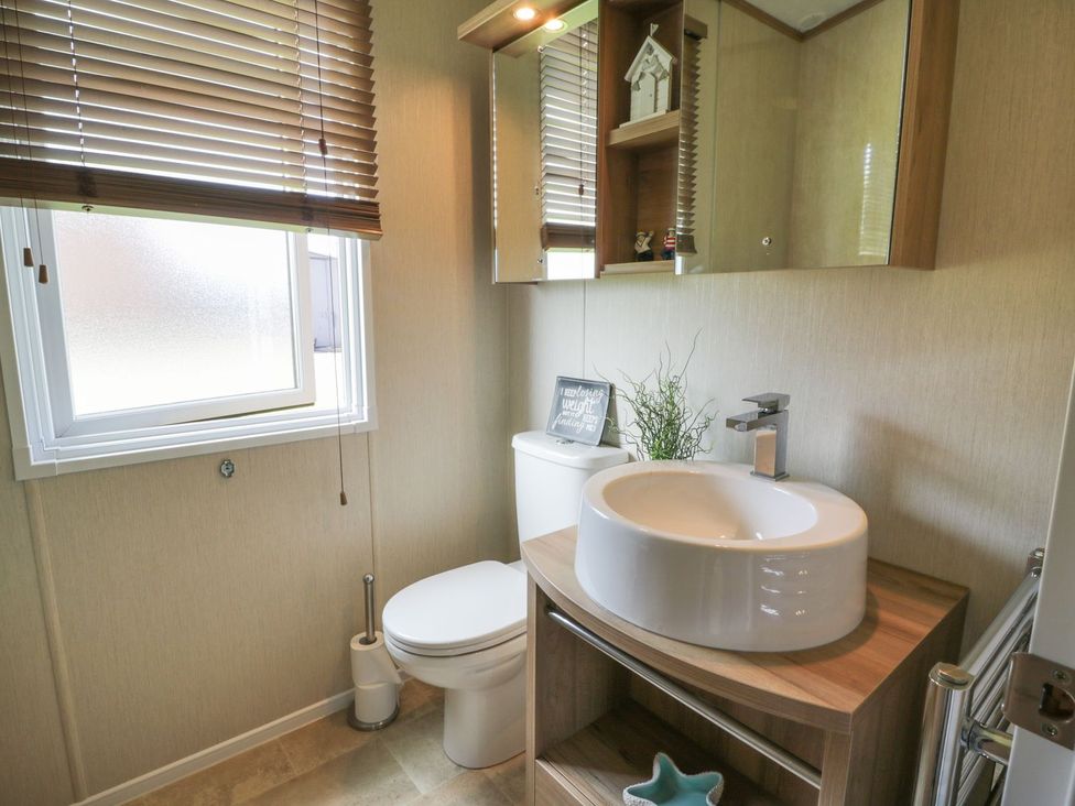 A bathroom with a toilet, sink and window at 1, Fisherman’s hill