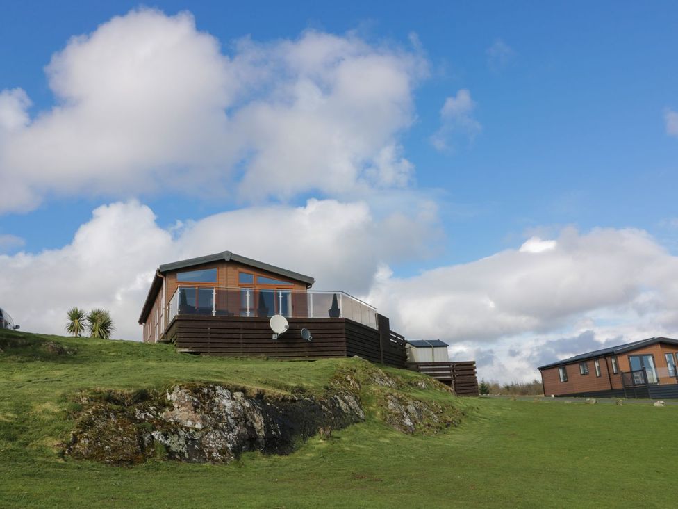 A house on a hill with decking and a satellite dish at 1, Fisherman’s hill