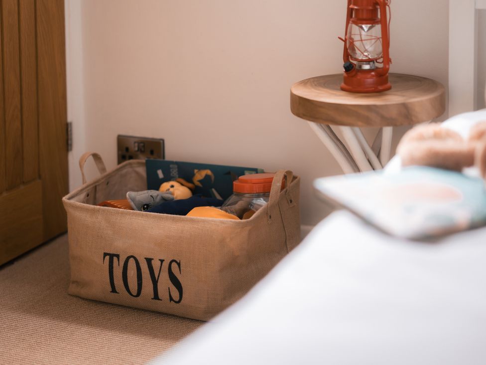A toy basket and lamp in a bedroom at 28 Piazza St Ives