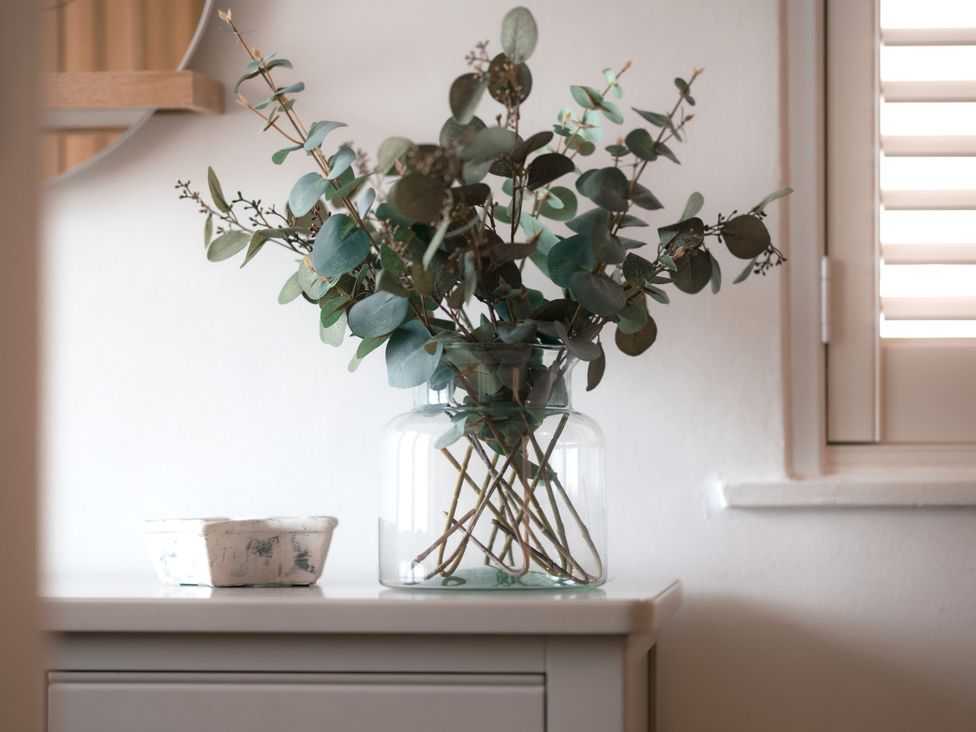 A decorative arrangement of eucalyptus in a vase on a table at 28 Piazza St Ives