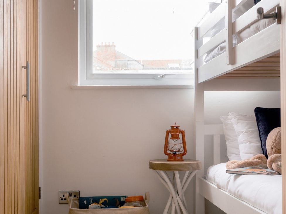 A bedroom with a bunk bed and side table at 28 Piazza in St Ives