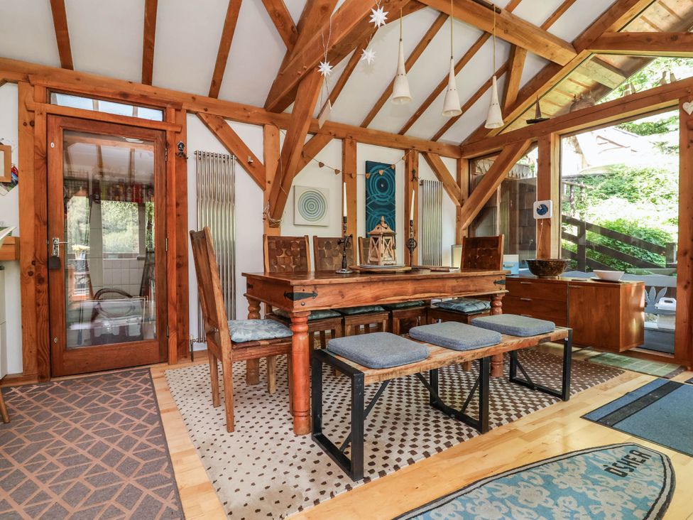 A dining room with a wooden table and chairs at The Boat House in Rudyard Lake