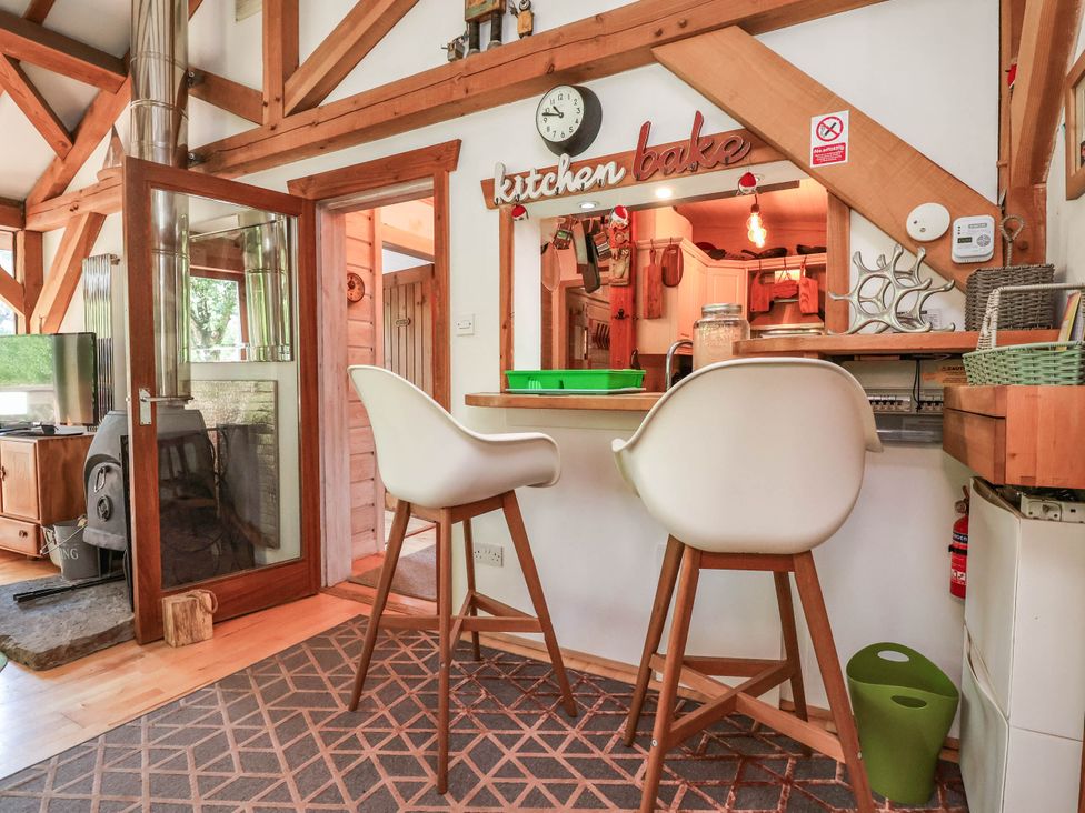 A kitchen with bar stools and a television at The Boat House Rudyard Lake