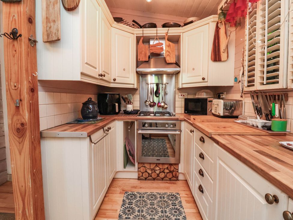 A kitchen with cabinets and appliances at The Boat House in Rudyard Lake