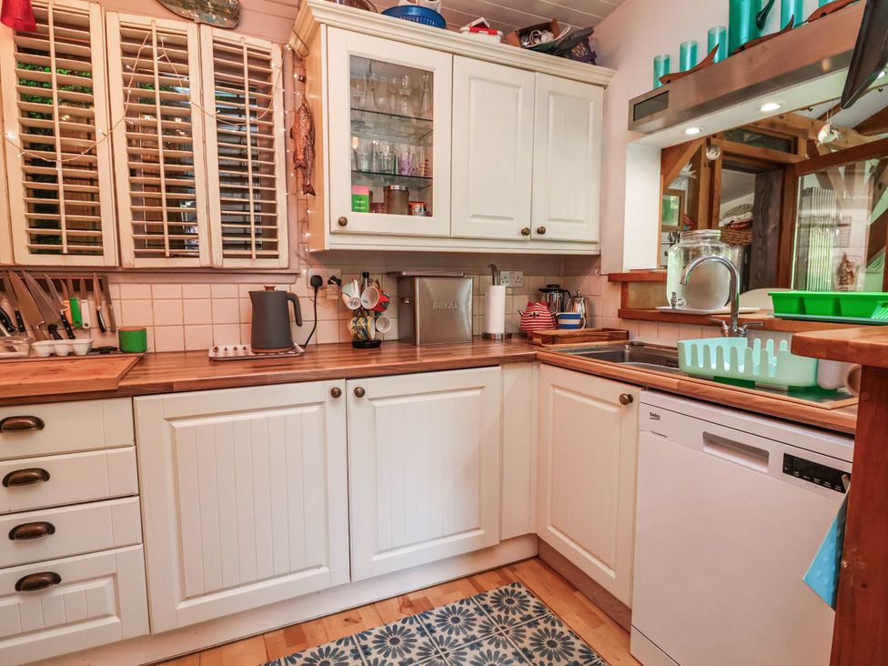 A kitchen with cabinets, sink, and dishwasher at The Boat House Rudyard Lake