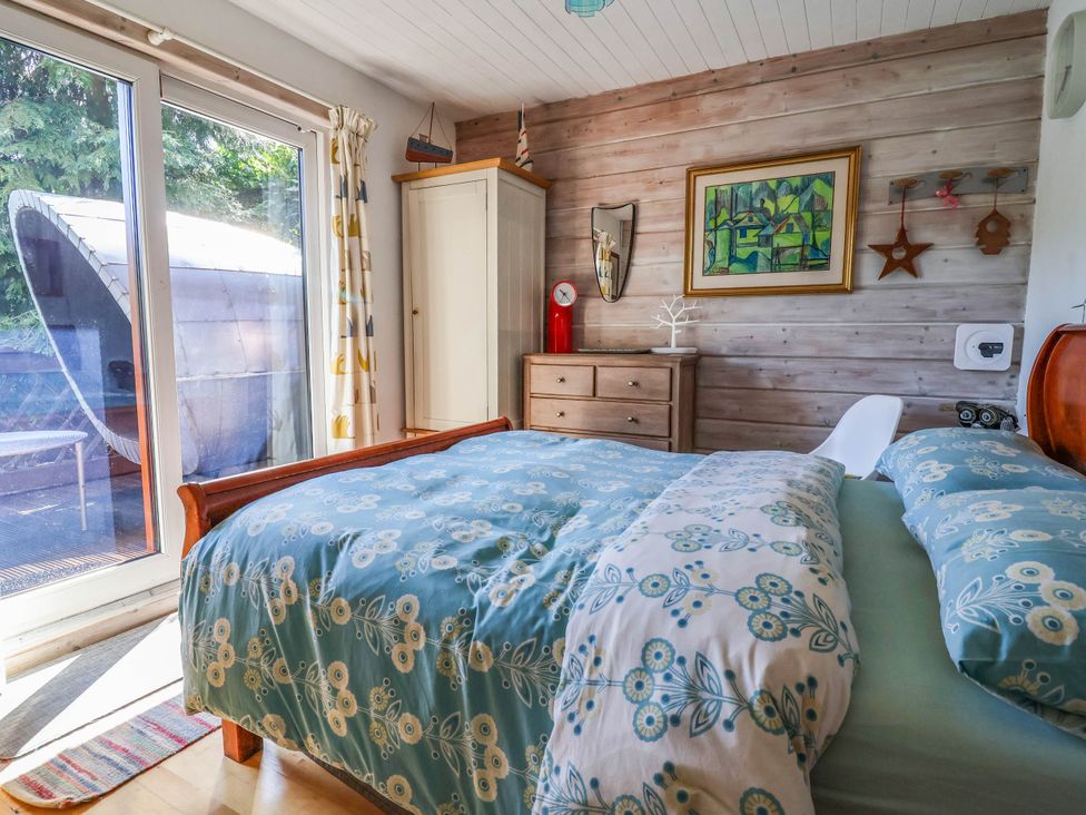 A bedroom with a bed and dresser at The Boat House in Rudyard Lake