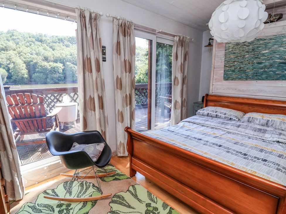 A bedroom with a bed and rocking chair at The Boat House Rudyard Lake