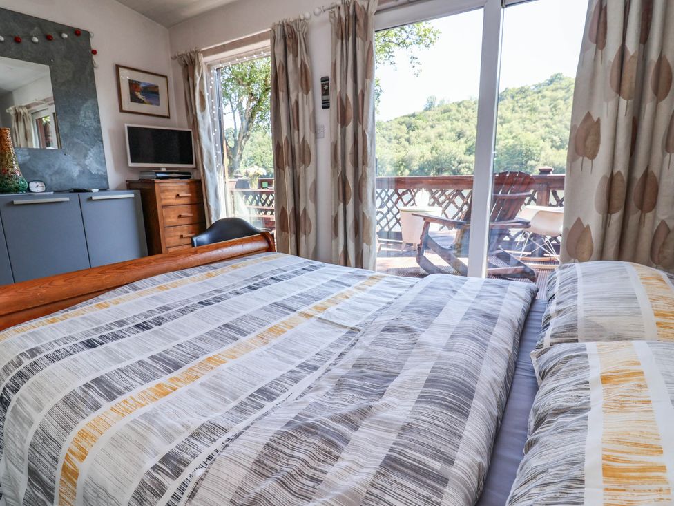 A bedroom with a bed and television at The Boat House Rudyard Lake