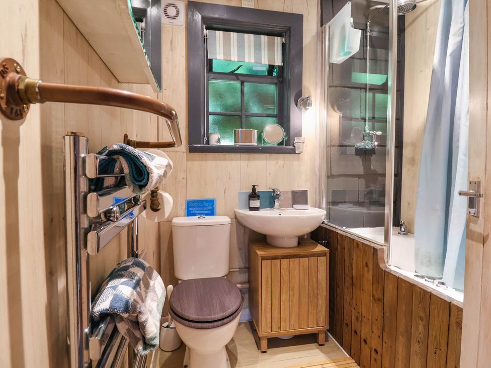 A bathroom with a toilet, sink, and shower at The Boat House in Rudyard Lake