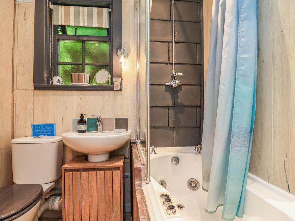 A bathroom with a toilet, sink, shower, and bathtub at The Boat House Rudyard Lake
