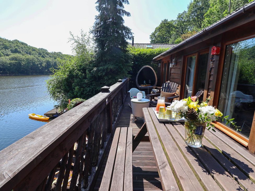 A deck with a table and lake view at The Boat House Rudyard Lake