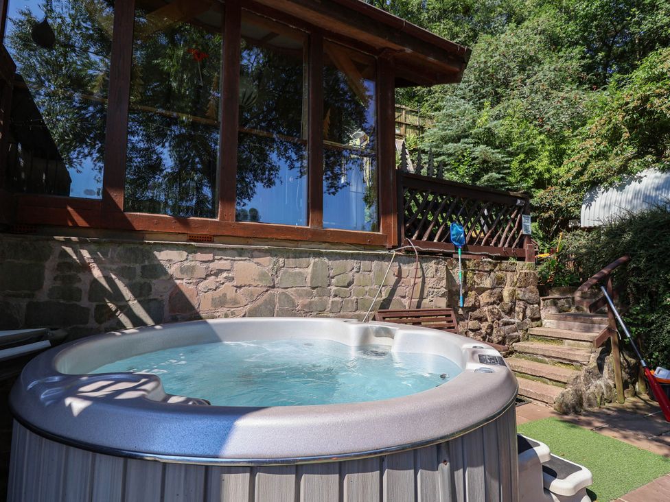 A hot tub surrounded by a garden at The Boat House in Rudyard Lake