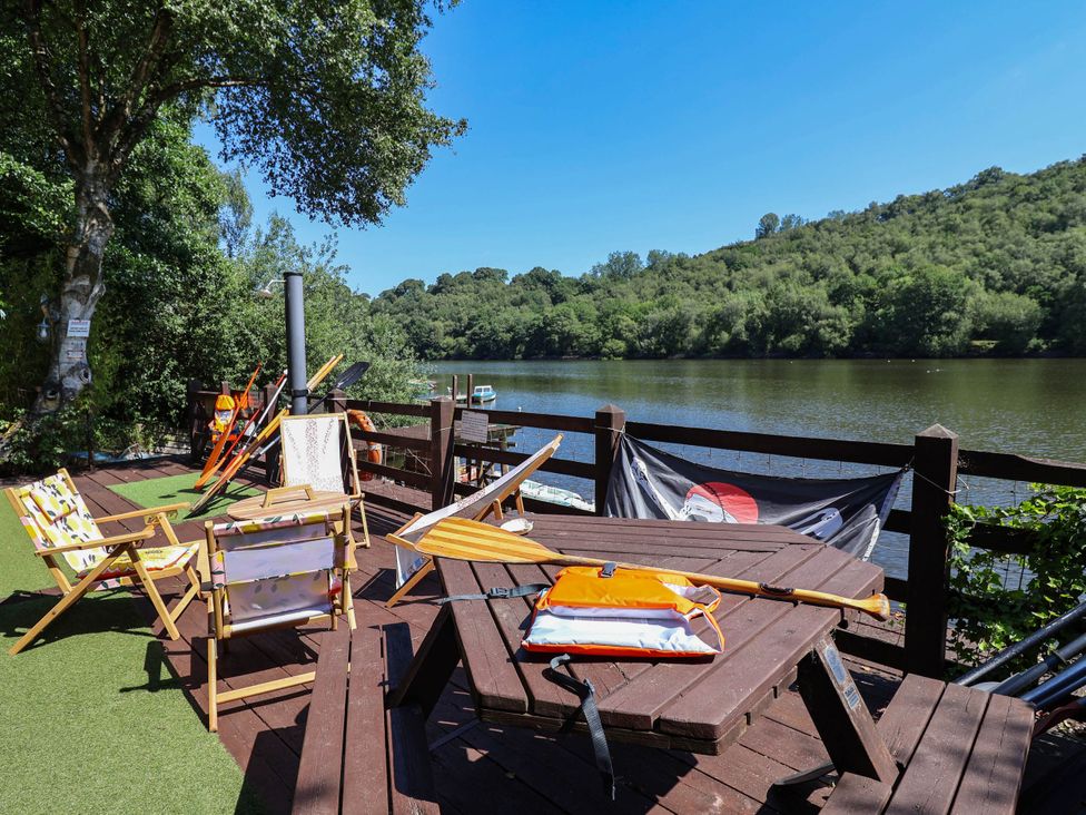 An outdoor area with a deck, table, and chairs at The Boat House Rudyard Lake