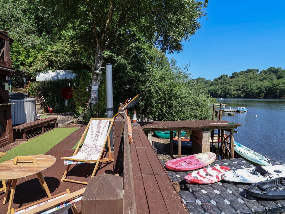 An outdoor area with deck chairs and kayaks at The Boat House in Rudyard Lake