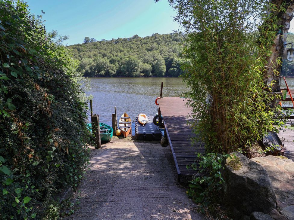 A dock with kayaks by a river at The Boat House Rudyard Lake