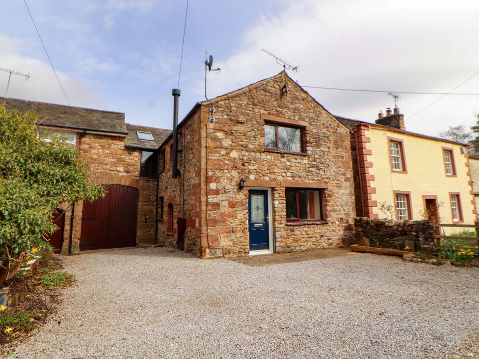 A stone house with a gravel driveway at The Barn in Warcop
