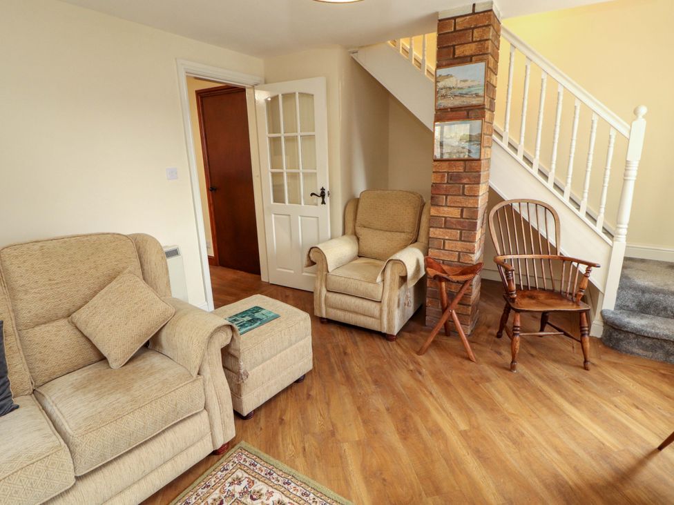 A living room with a sofa, armchair, and table at The Barn in Warcop