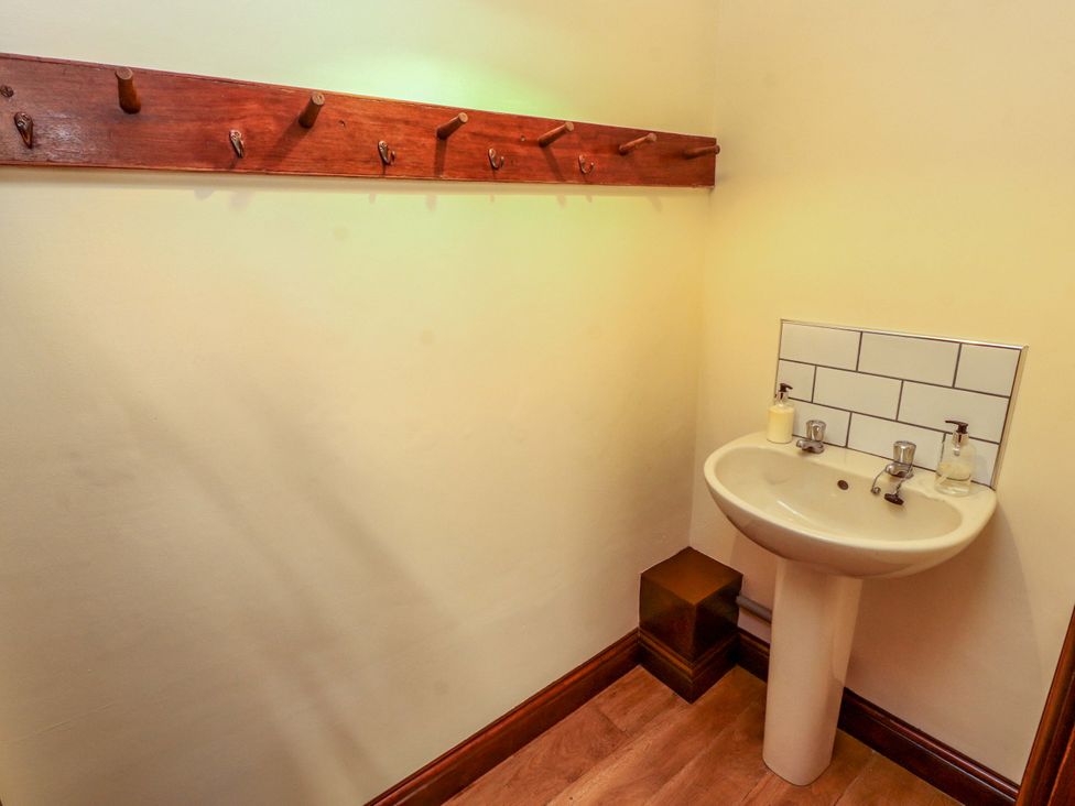 A bathroom with a sink and coat hooks at The Barn in Warcop