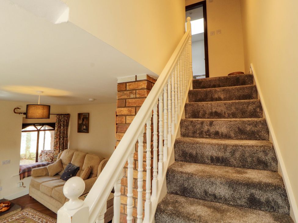 A staircase with carpet and a light fixture at The Barn in Warcop