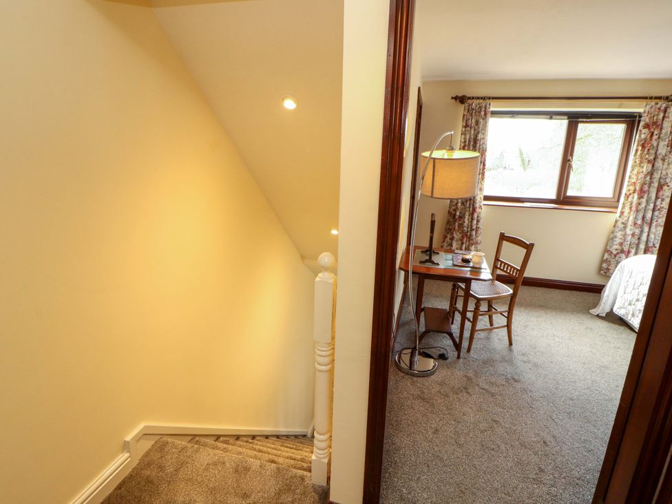 A bedroom with a table and chair near a window at The Barn in Warcop