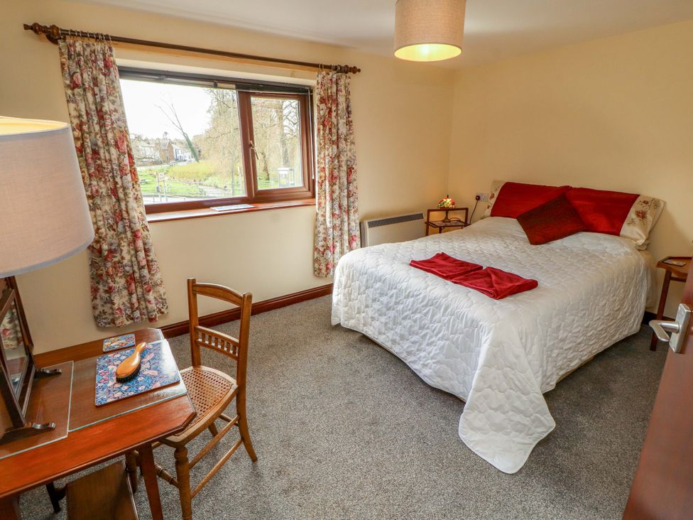 A bedroom with a bed and desk at The Barn in Warcop