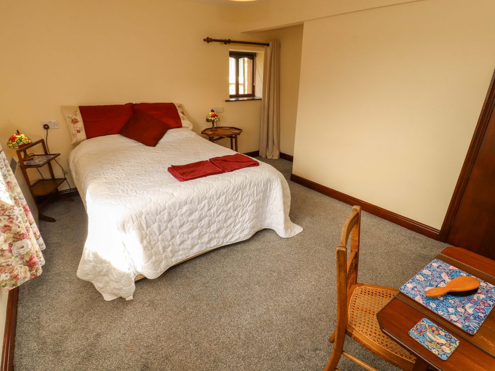 A bedroom with a bed and table at The Barn in Warcop