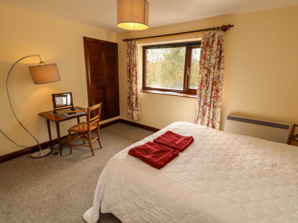 A bedroom with a bed and desk at The Barn in Warcop