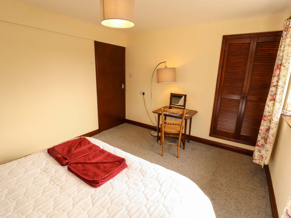 A bedroom with a bed and a chair at The Barn in Warcop