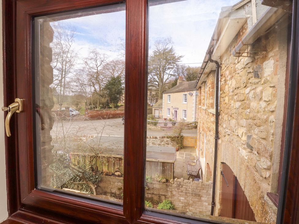 View of trees and buildings from a window at The Barn in Warcop