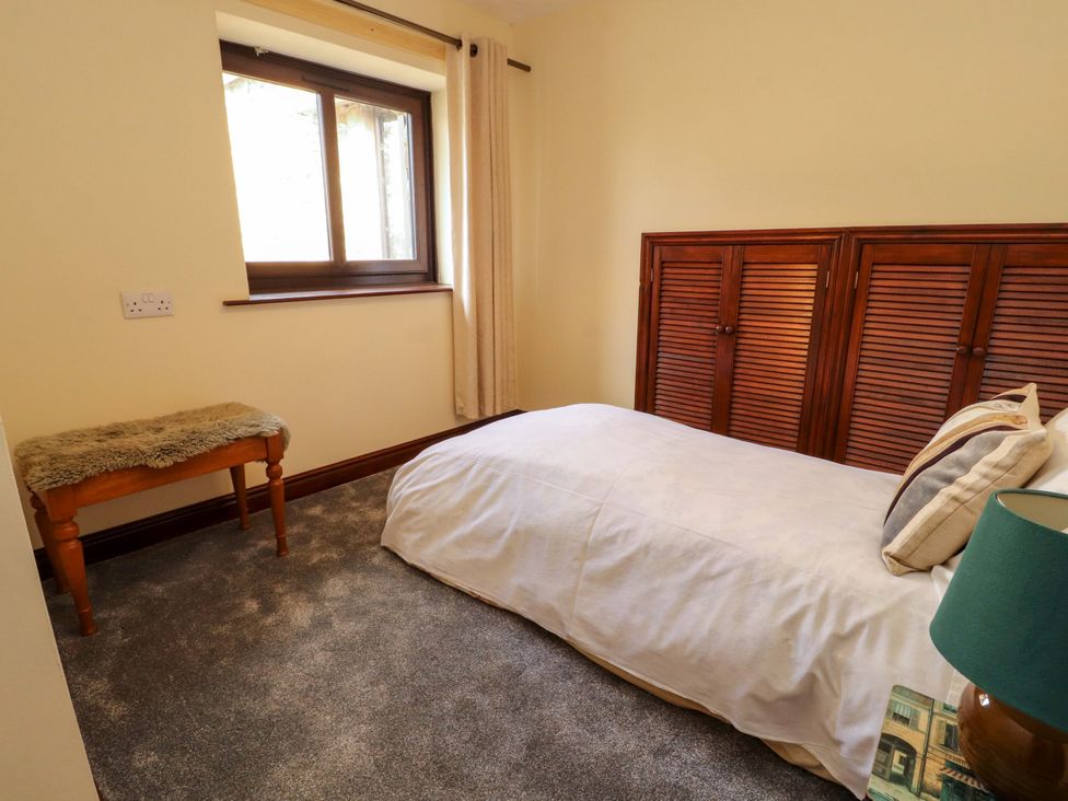 A bedroom with a bed and a bench at The Barn in Warcop