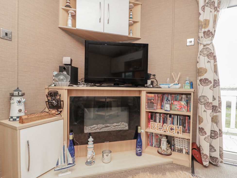 A living room with a television and decorative items at 37 Redcar