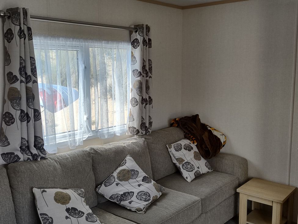 A living room with a sofa and curtains at Sands Retreat in Redcar