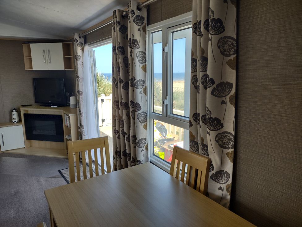A dining room with a table and chairs at Sands Retreat in Redcar