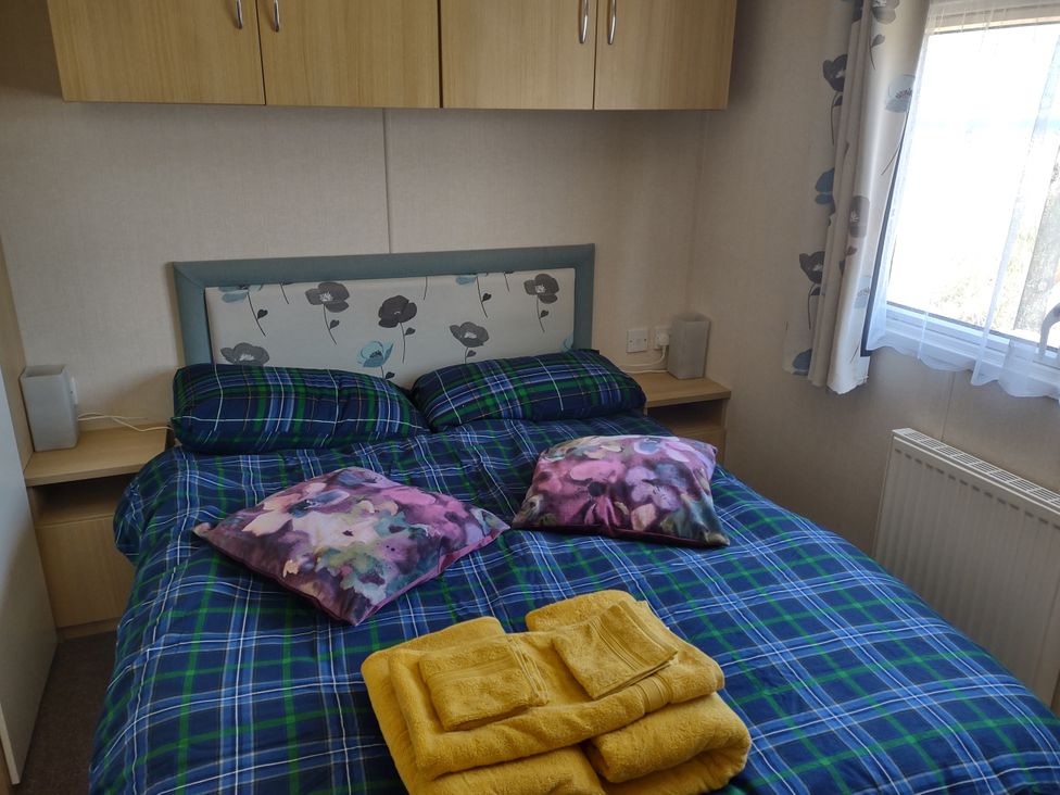 A bedroom with a bed and towels at Sands Retreat in Redcar